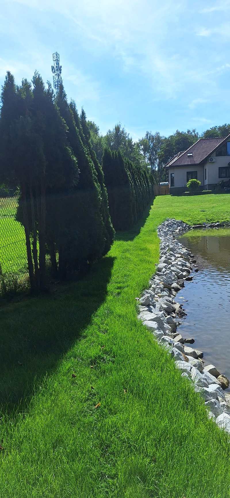 Ogród ze stawem i kamiennym obrzeżem